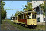 Triebwagen 56 der VAG steht mit dem Beiwagen 135 am 30.09.2023 an der Endstelle in Freiburg-Rieselfeld für eine Sonderfahrt bereit. Im Hintergrund schaut Wagen 265 um die Ecke.