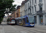 VAG: Die meisten neuen spanischen Strassenbahnen der Freiburger Verkehr AG (VAG) rollen bereits mit einer Vollwerbung auf dem Strassenbahnnetz von Freiburg in Breisgau. Zur Zeit noch unentbehrlich sind die alten Düwag-Gelenkwagen. Die Aufnahme stammt vom 21. Juni 2016.
Foto: Walter Ruetsch