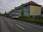 Die Häuser in der Jenaer Karl-Liebknecht-Straße entstanden etwa in der gleichen Zeit, wie Triebwagen 26. Auch die Fahrleitungsmasten stammen aus vergangenen Zeiten. Gerade hat der Triebwagen am 29.11.2025 die Endhaltestelle Jena-Ost verlassen und ist auf den Weg in Richtung Zentrum. 