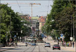 Ein tiefer Blick in die Münchner Maximilianstraße -    Die Straßenbahn der Linie 19 hat das Maxmonument umfahren.