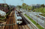 Zug der DB-Baureihe 427 auf DB-Gleisen neben der Stuttgarter Stra�enbahnlinie 13 neben der Stra�enbahnstation Kienbachstra�e (1984) 