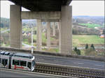 Unter dem Autobahnviadukt ins Tal hinunter -    Eine GT-N-Tram in der steilen Gefällstrecke von Würzburg-Heuchelhof bei der Abfahrt hinunter ins Maintal.