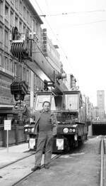 SSB Stuttgart__Arbeitsfahrzeuge der SSB in den 70er und 80er Jahren. Kurz vor Eröffnung der Tunnelstrecken und U-Haltestelle Hbf. Der gut beschäftigte 'Bavaria' Schienenkran 2502 und sein  Chauffeur  in der Königstraße mit Blick zum Bahnhofsturm.__08-04-1976