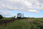 SIEAG 247 908  Debbie  ist am 31.05.2022 für RDC Autozug mit einem blauen Autozug von Westerland(Sylt) nach Niebüll unterwegs und erreicht hier den Betriebsbahnhof Lehnshallig.