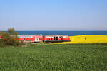 DB 218 435-6 schiebt die RB85 von Lübeck Hbf kommend nach Neustadt in Holstein und taucht hier zwischen Raps und Ostsee bei Sierksdorf auf.