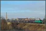Vorbei an alten Industrieanlagen verlässt 145-CL 005 (einst für Rail4Chem, nun für Crossrail im Einsatz) mit einem Autozug die Stadt Magdeburg Richtung Osten. (Magdeburg-Neustadt, 07.02.2015)