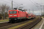 DB Regio 112 102 mit dem RE3 von Wilmersdorf bei Angermünde nach Stralsund Hbf, zu sehen beim Halt in Wüstenfelde (11.02.2022).