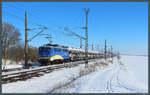 Bei schönstem Winterwetter zieht 140 798-0 der EVB einen Autozug mit passend zur Umgebung verkleideten Fahrzeugen durch die Börde bei Wellen. (14.02.2021)