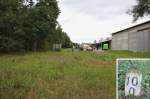 25.8.2015 Straach, ehemaliges Bahnhofsgelände. Wo sich im Hintergrund der die Vegetation nach rechts ausdehnt, ließ sich in der Ecke noch Nummernstein 10.0 der 10.2 langen Strecke von Lutherstadt Wittenberg finden.