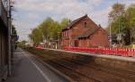 Bahnsteig 2 und Bahnsteig 1 mit Bauzaun und altem Bahnhofsgebude aus der Zeit als die Strecke gebaut wurde.