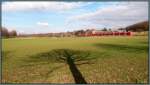 Noch ist der Baum recht nackt und wirft seinen Schatten ins Bild,die Rhein Niers Bahn macht sich unterdessen auf der KBS 485 nach Duisburg weiter.