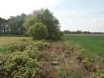 Blick zurück nach Rheindahlen. Man erkennt gut dass das Gleis in die Stadt von der Natur schnell zurück erobert wird.  Mitte der 1950er Jahre wurden gleich zwei Anschlüsse für das NATO-Hauptquartier nordöstlich von Rheindahlen neu angelegt. Dies waren die Anschlußgleise Holt I(Bild) und Holt II der britischen Rheinarmee. Das Anschlußgleis Holt II verlief bis zum östlichen Ortsausgang Rheindahlens parallel zum Eisernen Rhein. Dort zweigte diese Anschlußbahn in nördlicher Richtung ab und endete auf einem Armeegelände kurz vor der Autobahn A 61 bei Genhülsen.
Nahe Rheindahlen 26.04.2014