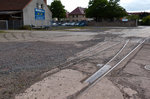 BILD1: Ein Relikt aus vergangenen Tagen: In Nordhausen in der Straße  An der Bleiche  befindet sich auf einem zugänglichen Brachgelände (rechts hinten im Bild, wird als Parkplatz genutzt) diese Gleisfragmente, die auf meinen Fotostandpunkt auf eine Drehscheibe zulaufen, mehrere Spurweiten treffen sich an dieser. Bis zur Wende wurde über das rechte Gleis Stahl angeliefert und über die Drehscheibe auf andere Wagen verteilt um zu umliegenden Gebäuden zu gelangen Um die ganze Anlage zu dokumentieren, bedarf es einer halben Fotoserie. 15.05.2016