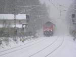 Aus dichten Schneetreiben im Freiberger Stadtwald kommt eine unbekannt gebliebene 143 mit RB 17323 von Zwickau nach Dresden, kurz vor dem Halt in Freiberg, 25.11.08