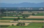 Ein neuer Anblick im Markgräflerland ist die BR 462. Aus den Auggener Weinbergen reicht der Blick bis zum Molkenrain und weiter links bis zum 60 km entfernten Elsässer Belchen. Der Industrieriegel befindet sich schon hinter der Grenze zu Frankreich. Juli 2020.