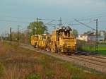 Eine  Schotterbrste  und ein Schienenstopfer am 13.04.12 im Abendlicht bei Buggingen.