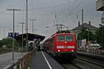 111 064 mit einem RE von Offenburg nach Schliegen am Nachmittag des 30.07.14 im strmenden Regen beim Halt in Mllheim (Baden).