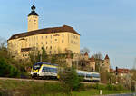Zwischen Büschen und Seniorenheim Schloss Horneck durcheilt der 8442 118 Gundelsheim, bis er am Bahnsteig hält als RE10a nach Heilbronn am Montag den 11.4.2022 