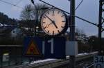 Analoge Bahnhofsuhr in Neckargerach, wenigstens etwas erinnert noch an die gute alte Zeit bei der Eisenbahn, als die meisten Zge auch noch pnktlich fuhren....9.2.2013.....ach ja, ich weiss nicht wie genau es zu erkennen ist, aber auf den Glas spiegelt sich das Gitter der Fugngerbrcke.