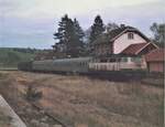Abendlicher Zughalt in Hausen vor Wald 1986 mit Güterwagen als Abschluss. Aufnahme vom gegenüberliegenden Gütergleis (links mit Rampe).