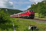 Von Ulm kommend schiebt 218 432-3 die Wagen des RE 22306 im Oberen Donautal unterhalb von Schloss Werenwag durch den Bahnhof von Hausen im Tal (31.05.2019).