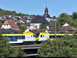 Züge unter der Christ-König-Kirche:  Zwei Stadler FLIRT 160 der Go-Ahead Baden-Württemberg GmbH (GABW) als RE 19023 (RE1) von Karlsruhe Hbf nach Stuttgart Hbf fahren in Ersingen