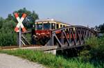Ein Schienenbus der Unteren Kochertalbahn (WEG) überquert eine Eisenbahnbrücke über den Kocher, 27.08.1985