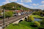 Die Werbelok 185664 von Kombi Verkehr verläßt hier am 30.4.2023 um 14.51 Uhr Gemünden am Main und fährt weiter über die KBS 801 in Richtung Fulda.