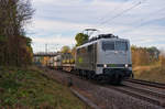 Eine Baureihe 111 von Railadventure mit einem Flachwagen mit Hilfsdrehgestellen und zwei Schutzwagen bei Postbauer-Heng Richtung Passau, 20.10.2019