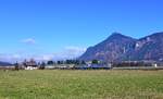 Vor dem 1368m hohen Kranzhorn ist am 09.02.2026 ein Railpool-Doppel aus 6193 170 und 6193 141 mit einem geschlossenen Altmann-Autozug bei Niederaudorf in Richtung Italien unterwegs. Im Hintergrund liegt die zu dieser Jahreszeit typische Nebelschicht über dem Rosenheimer Land.