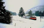 Winter im Bayerischen Oberland: Eine orientrot lackierte 218 fährt Ende November 1998 in der Nähe von Fischbachau an der Krugalm vorbei