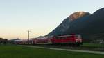 111 066 zieht den Verstärker-RE nach Mittenwald im schwindenden Licht über die Felder zwischen Farchant und Garmisch-Partenkirchen.