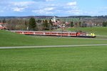  Für Menschen unterwegs  ist die ADAC Werbelok 111 024 und schiebt hier gerade die RB 59546 nach München an der Ortschaft Polling vorbei. Die spätgotische Klosterkirche dominiert das Ortsbild (13. April 2013).