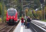 Während, Jeanny, Ivie und Hans in der  Masse  der Reisenden auf das Hamsterbäckchen warteten, hatte ich mich hundert Meter abgesetzt, um die Szene auf den Chip zu bannen. 2442 228 ist als RB nach München Hbf. unterwegs und fährt in den Bahnhof Klais ein, der für den G 7 Gipfel herausgeputzt wurde. Wir werden nur bis Murnau mitfahren, denn wir wollen zum Schloß Linderhof. In Murnau geht es weiter mit einem Minihamster bis Oberammergau und dann mit dem Bus (RVO) bis nach Linderhof. Bahnstrecke 5504 München Hbf. - Mittenwald Grenze am 09.10.2015