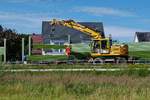 Entlang den Gleisen der Allgubahn werden in Weiensberg am 08.07.2020 mit einem Zweiwegebagger Schallschutzelemente zwischen den Doppel-T-Trgern eingefhrt.