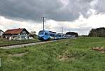 Unter einer aufziehenden dicken Regenwolke ist hier der GoAhead Triebzug 4.14 am 2.5.2023 um 16.35 Uhr bei Grabus in Richtung Memmingen unterwegs.