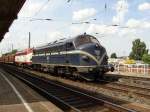 Zwei NOHABs fahren mit einem langen Holzzug duch den Bahnhof Magdeburg-Neustadt.