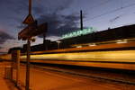 Vor dem Kornwestheimer Wahrzeichen, dem Salamander-Schriftzug auf dem ehemaligen Fabrikgebäude, eilt ein Flirt auf Gleis 5 durch den Kornwestheimer Personenbahnhof 🧰 Go-Ahead