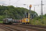 185 547-7 mit Kohlewagen in Köln West. Im Hintergrund werden mit dem OL-Triebwagen der DB-Netzinstandsetzung Ausbildungen an der Oberleitung durchgeführt. Aufgenommen am 15.07.2014.