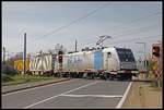 185 694 passiert am 2.04.2019 mit einem Güterzug den Bahnübergang in Lanzendorf - Rannersdorf.