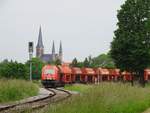 Nachdem sie Kalk ins Zementwerk nach Ennigerloh gebracht hat, passiert WLE 23 (223 057-1) die Katholische Kirche St.