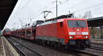 DB Cargo AG, Mainz mit ihrer ihrer  189 019-3  (NVR:  91 80 6189 019-3 D-DB ) und einem PKW-Transportzug (VW-Modelle) Richtung Frankfurt/Oder am 14.02.24 Durchfahrt Bahnhof Schönefeld bei Berlin.