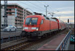 DB Regio 182 019-0 mit dem Flughafen Express (FEX) am 06.12.2025 in Berlin Ostkreuz. Jahrzehntelange hatte der Kreuzungsbahnhof den saloppen Spitznamen  Rostkreuz , seiner rostigen und maroden Stahlbrücken wegen. Heute ist die Station ein moderner Glas-Stahl-Betonbunker.