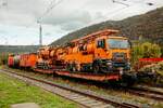 212 242-2 'Lok 7' Redler Service mit Sp�lzug mit zwei MAN Lkws auf Flachwaggons in Oberwesel, Oktober 2025. 