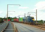 Ein bunter Gterzug, zu dem die farbenfrohe Lok auch passt, kommt von Jtland her auf die Kleinbeltsbrcke gefahren. Bald berquert die Fuhre die Meerenge des kleinen Belt. 19.08.2010.