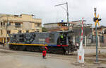 Die Lok auf dem Strassenübergang, die Schlagbäume offen im Bahnhof Yaguachi! Ein Mitarbeiter sichert den Übergang, während die Diesellok Nr. 2405 an die Zugspitze umsetzt. Yaguachi, 04.08.2018