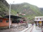 Der Bahnhof von Sibambe, Ecuador (rechts im Bild) mit einem Tanzpavillon (links) und dem Fuße der Teufelsnase (linker Berg) am 13.02.2011.