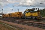 Gleisinstandhaltungsfahrzeug Tka 8  572 der VR Track mit 3 vollen Schotterwagen nach der Beladung  durch einen Pneubagger in Rovaniemi am 22.7.2014