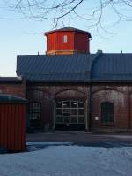 Letztes Sonnenlicht trifft noch den alten Wasserturm im BW Riihimki, whrend der Rundlokschuppen schon im Schatten liegt.