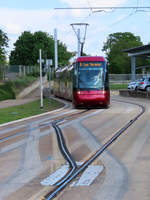 Spezielle Strassenbahn in Clermont-Ferrand an der Haltestelle La Pardieu Gare: Tramway sur pneumatiques (Strassenbahn auf Gummirädern), System Translohr. Die Fahrzeuge werden mittels einer Leitschiene in der Mitte geführt. Dieses Fahrzeug hat über die 'Weichenverbindung' im Vordergrund das Gleis gewechselt und fährt nächstens auf dem linken Gleis zum Bahnsteig. Clermont-Ferrand, 22.5.2023